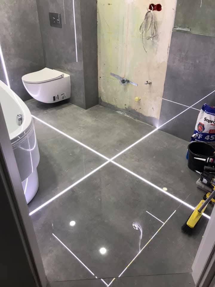 Bagno con grandi lastre e fughe LED a Toruń