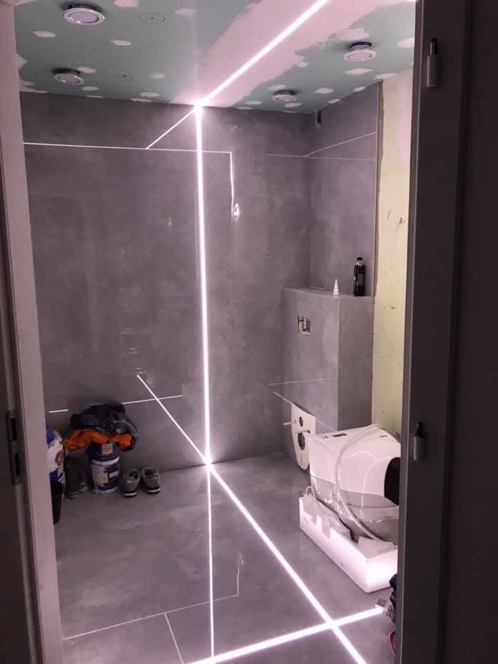 Bagno con grandi lastre e fughe LED a Toruń